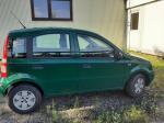 Samochód osobowy Fiat Panda w kolorze zielonym, podwozie skorodowane od strony koła